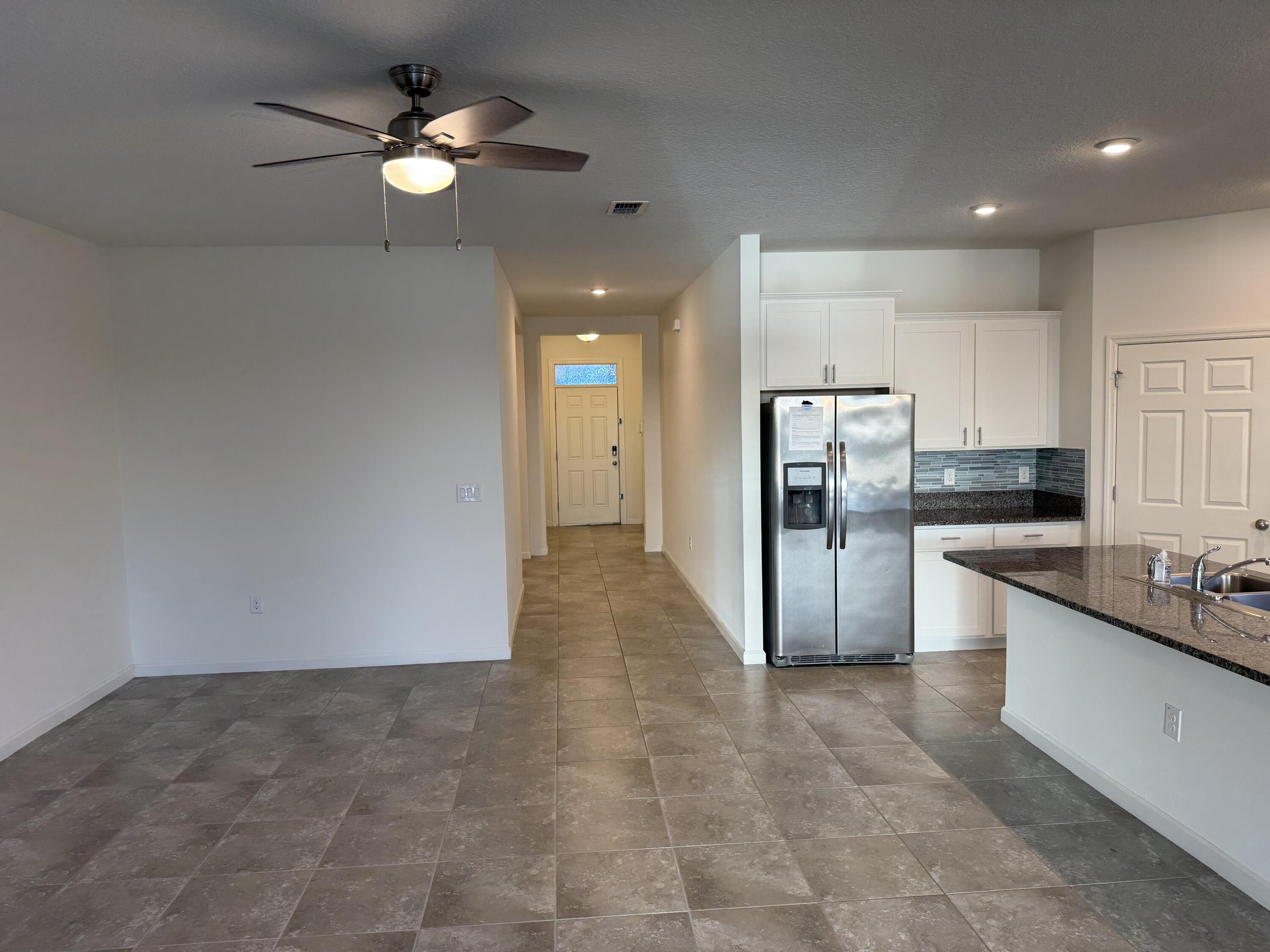 2608 Crowned Eagle Circle Southwest Vero Beach, FL 32962 - Photo 5 of 13 a kitchen with stainless steel appliances a refrigerator and a sink