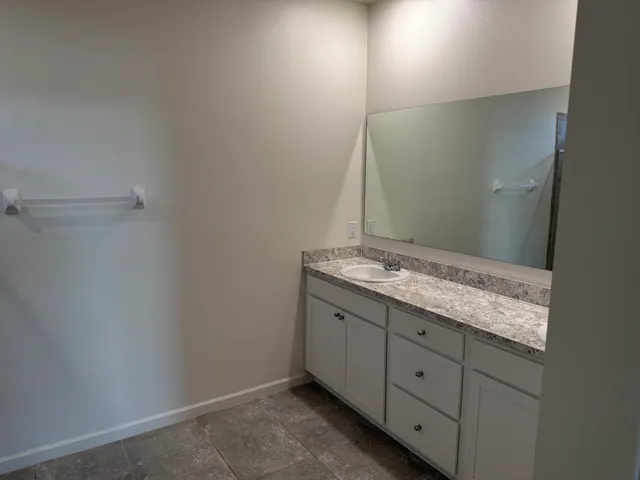 a bathroom with a granite countertop sink and vanity