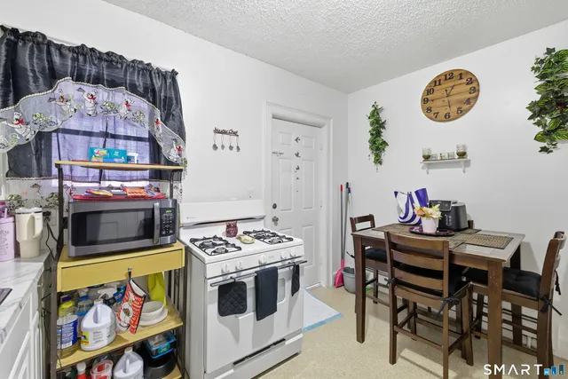 a dining room with a stove a table and chairs