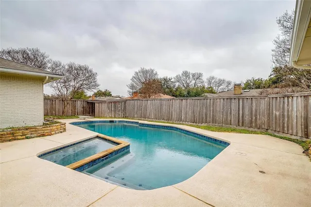 a view of a backyard with swimming pool and seating