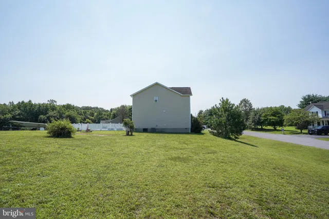 a backyard of a house with lots of green space and mountain view in back