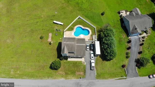 an aerial view of a house with a yard and a large tree