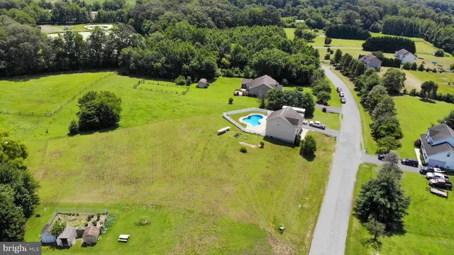 an aerial view of a house with a yard basket ball court and outdoor seating
