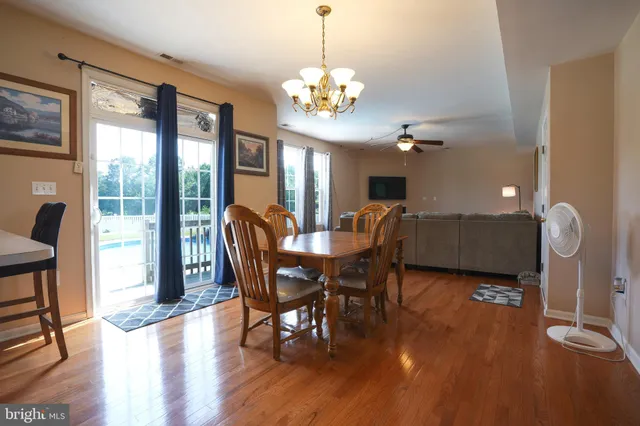 a view of a dining room with furniture a chandelier and wooden floor
