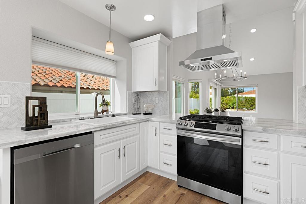 4710 Galicia Way Oceanside, CA 92056 - Photo 11 of 46 a kitchen with stainless steel appliances granite countertop a sink a stove and a wooden floors
