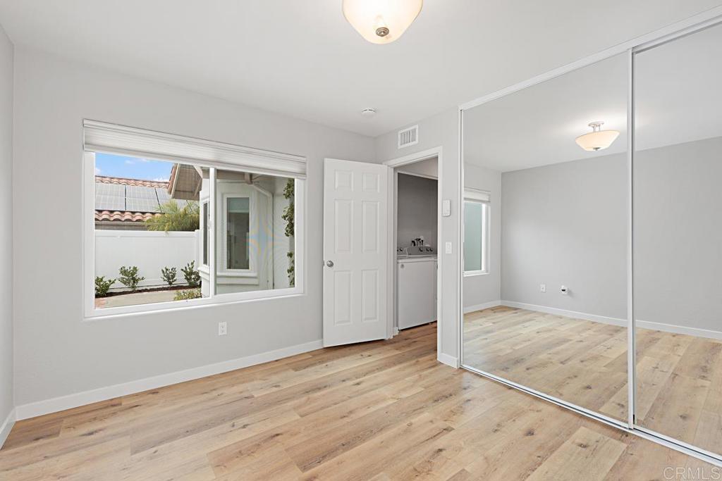 4710 Galicia Way Oceanside, CA 92056 - Photo 20 of 46 a view of an empty room with wooden floor and a window