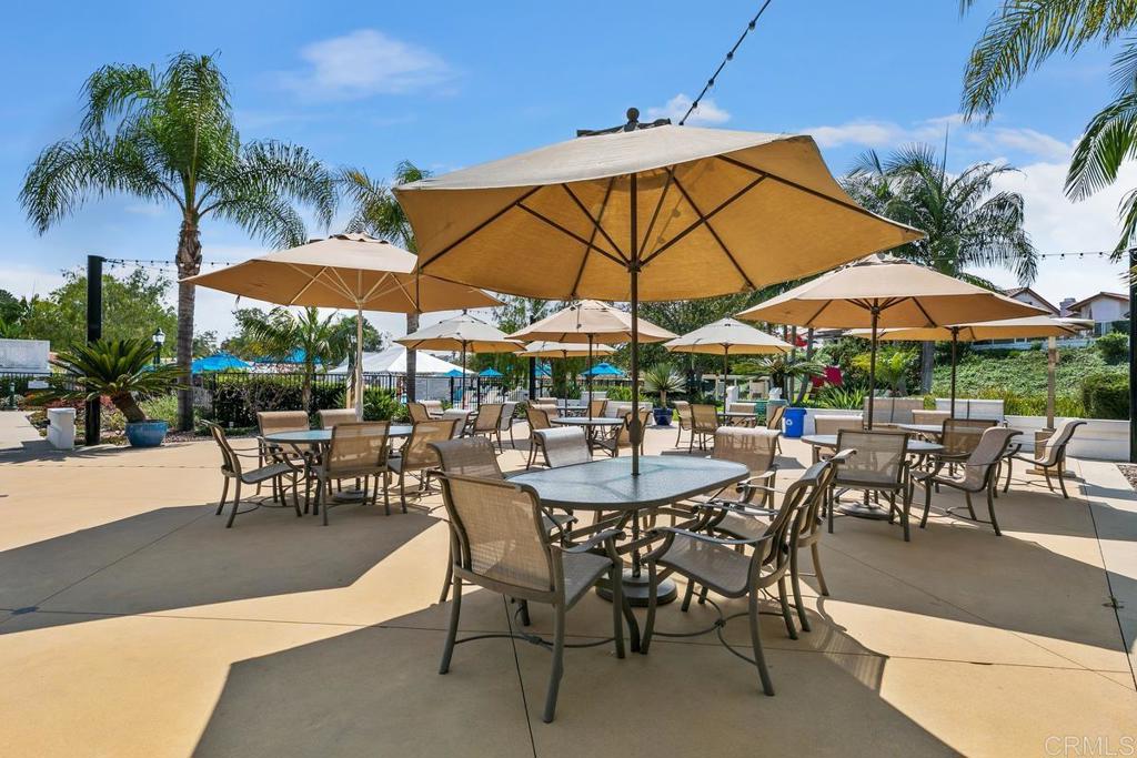 4710 Galicia Way Oceanside, CA 92056 - Photo 40 of 46 a view of patio with chairs and table under an umbrella