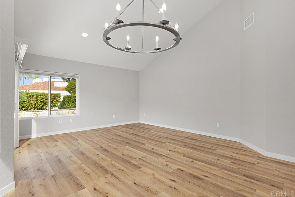 4710 Galicia Way Oceanside, CA 92056 - Photo 9 of 46 an empty room with a wooden floor and a window