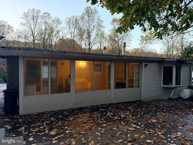 a view of a white house with a large tree and stairs