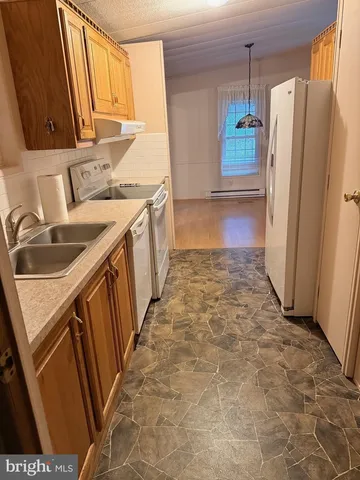 a kitchen with granite countertop a refrigerator and a sink