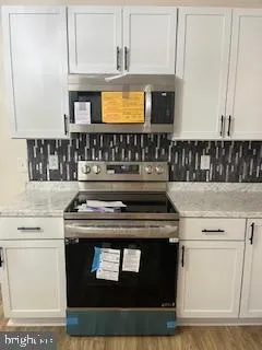 a stove top oven sitting inside of a kitchen