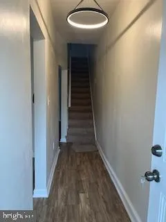 a view of a hallway with wooden floor and entryway