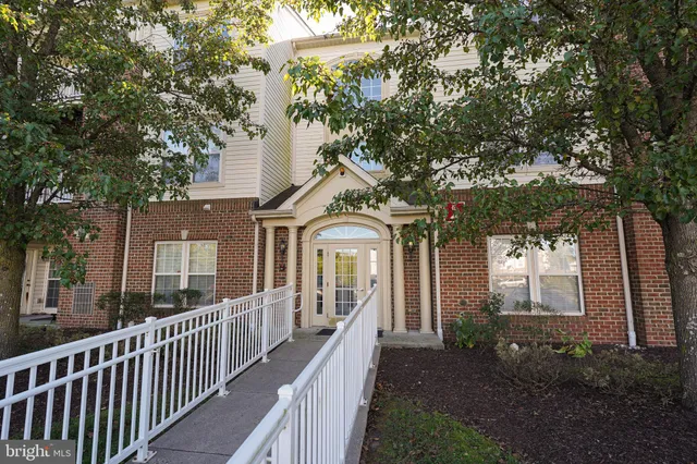 a view of a house with a yard and large tree