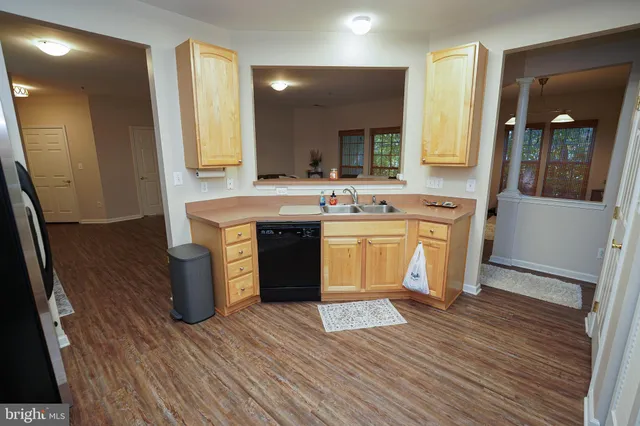 a view of a kitchen counter space with wooden floor and staircase