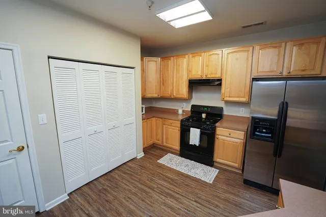 a kitchen with granite countertop wooden cabinets and a stove top oven