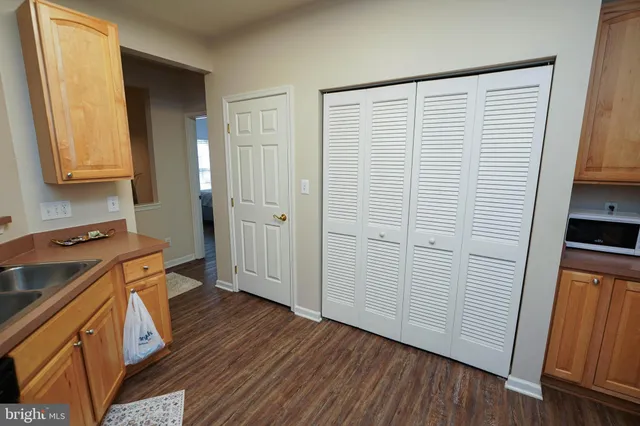 a view of a kitchen with a sink and wooden floor