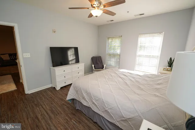 a bedroom with a bed and a flat tv screen on dresser