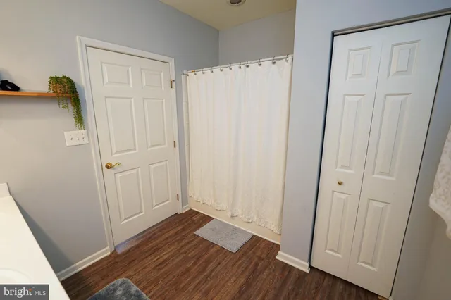 a view of a hallway with wooden floor and closet area