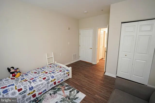 a bedroom with bed and wooden floor