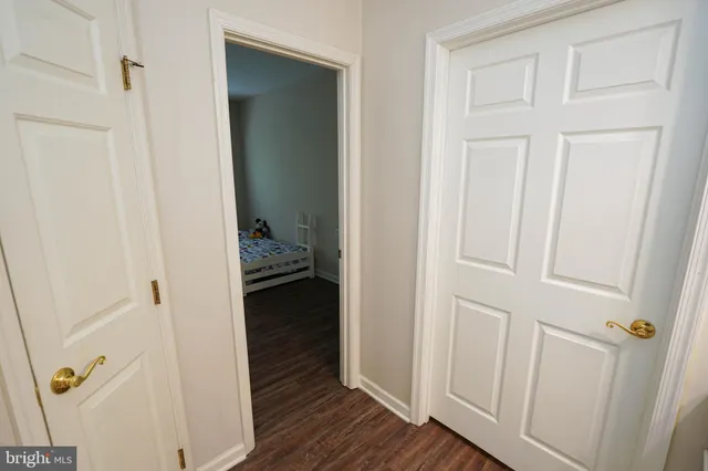 a view of a hallway with wooden floor and closet