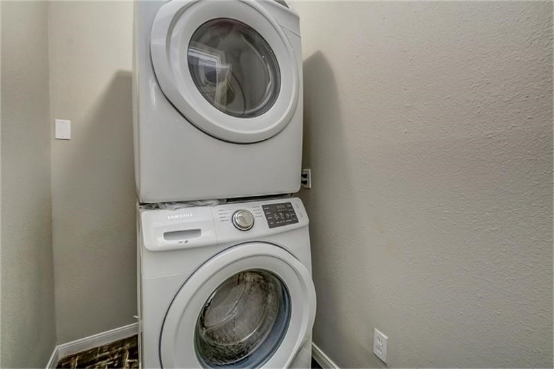 3502 Rosedale Street Houston, TX 77004 - Photo 17 of 17 Modern stacked washer and dryer set in a compact laundry area, offering convenience and efficiency.