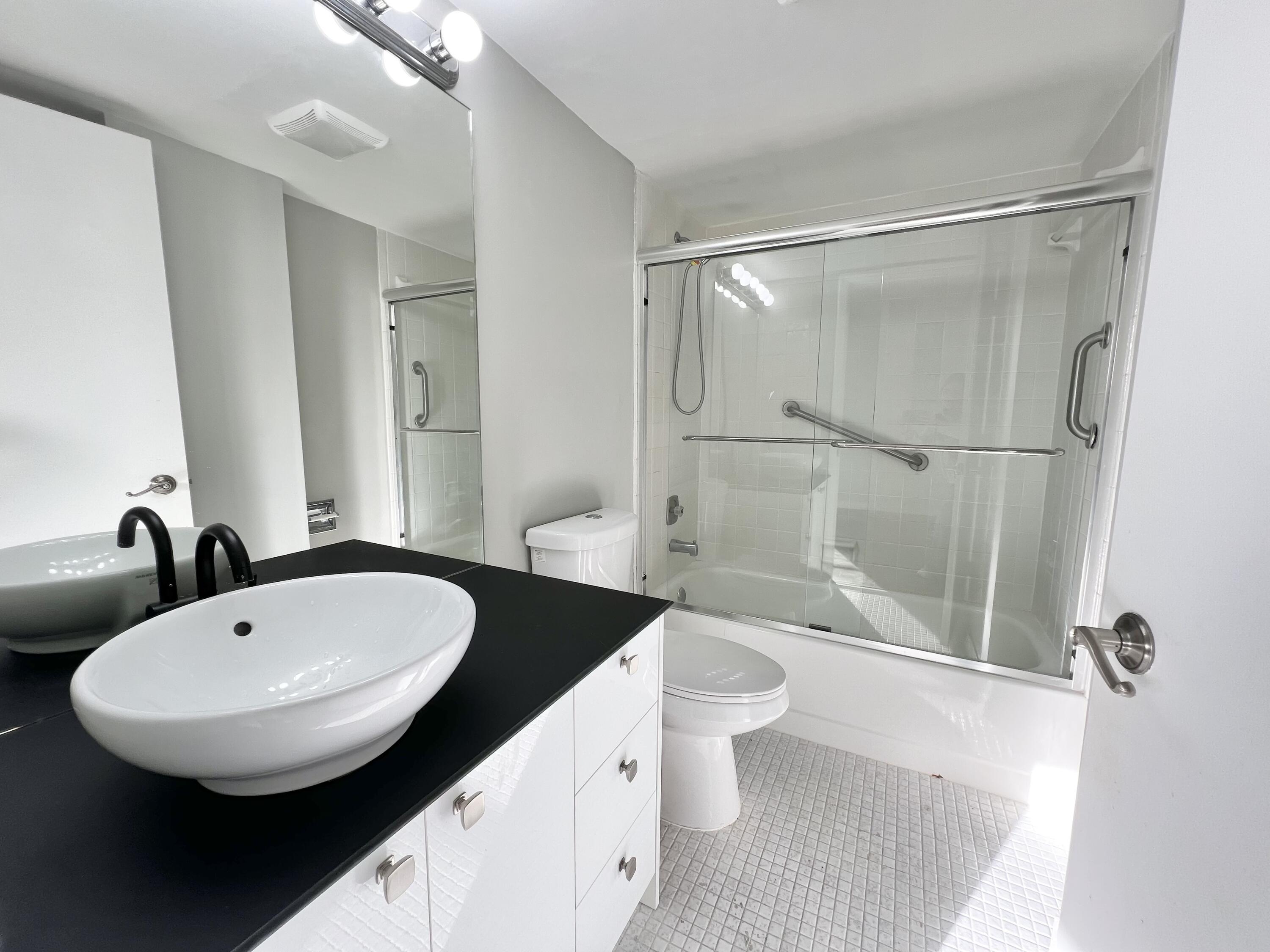 17 Royal Palm Way, Unit 503 Boca Raton, FL 33432 - Photo 15 of 29 a bathroom with a double vanity sink toilet mirror and shower