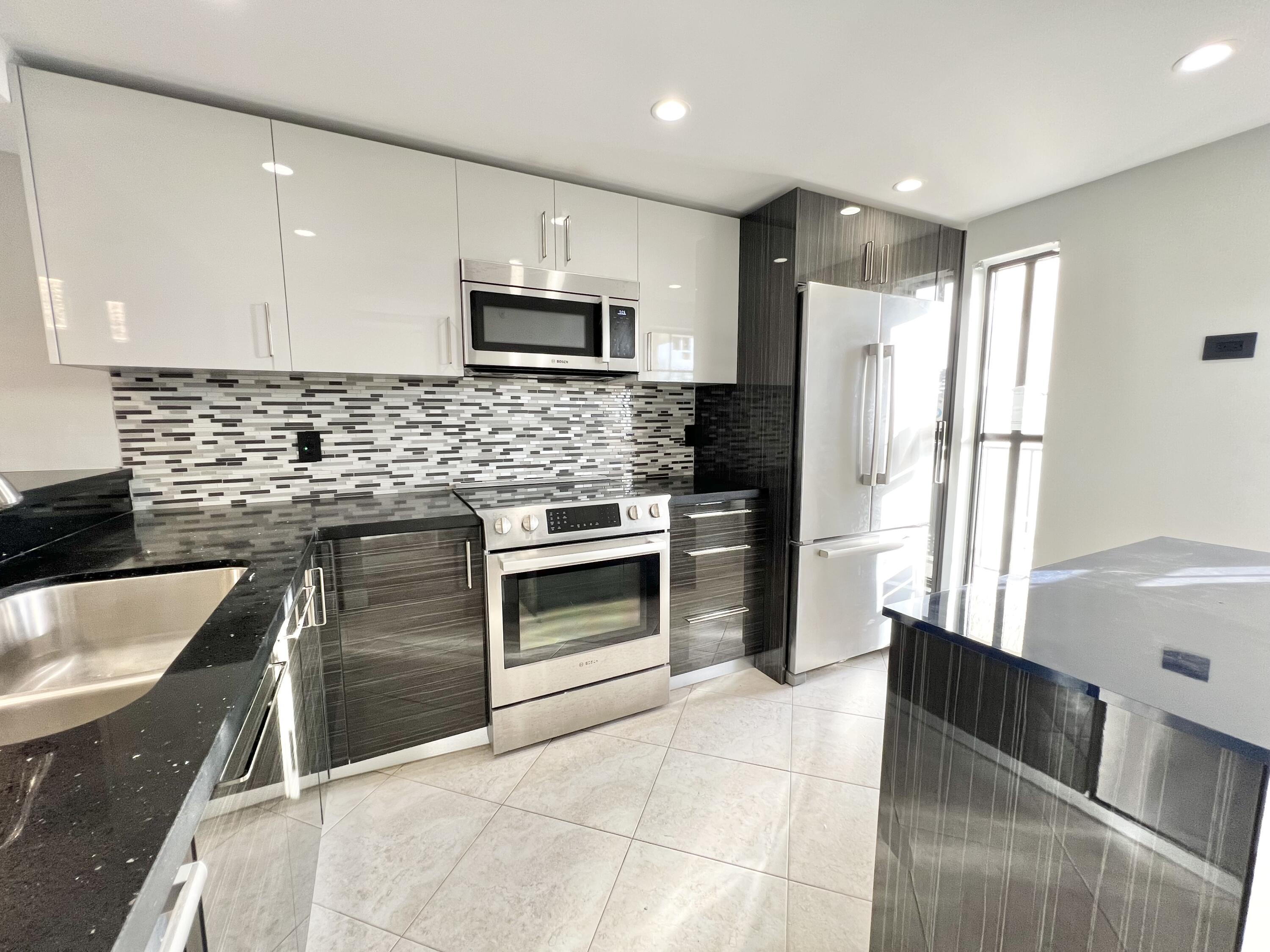 17 Royal Palm Way, Unit 503 Boca Raton, FL 33432 - Photo 2 of 29 a kitchen with stainless steel appliances granite countertop a sink stove and refrigerator