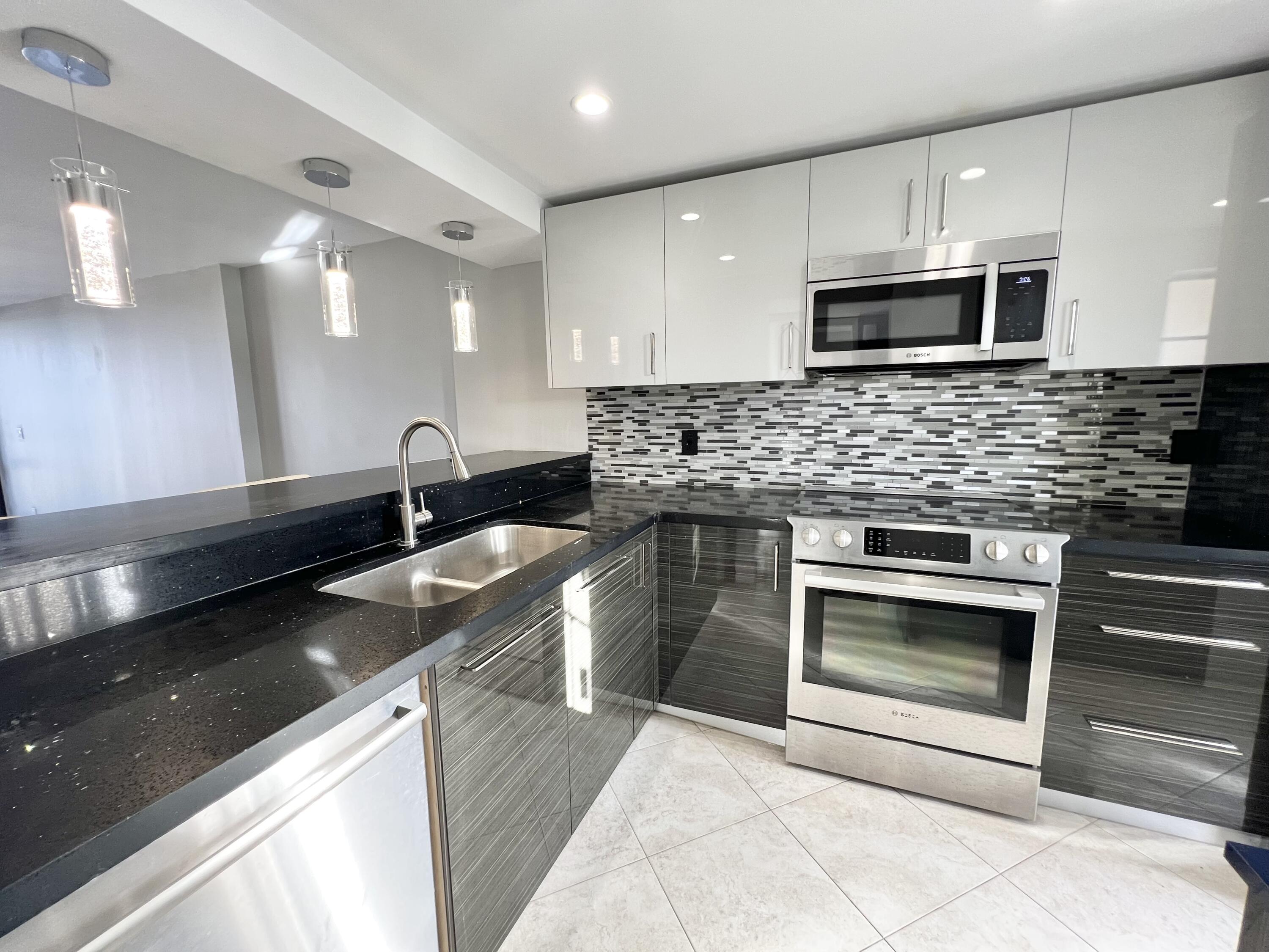 17 Royal Palm Way, Unit 503 Boca Raton, FL 33432 - Photo 3 of 29 a kitchen with stainless steel appliances kitchen island granite countertop a sink and a stove