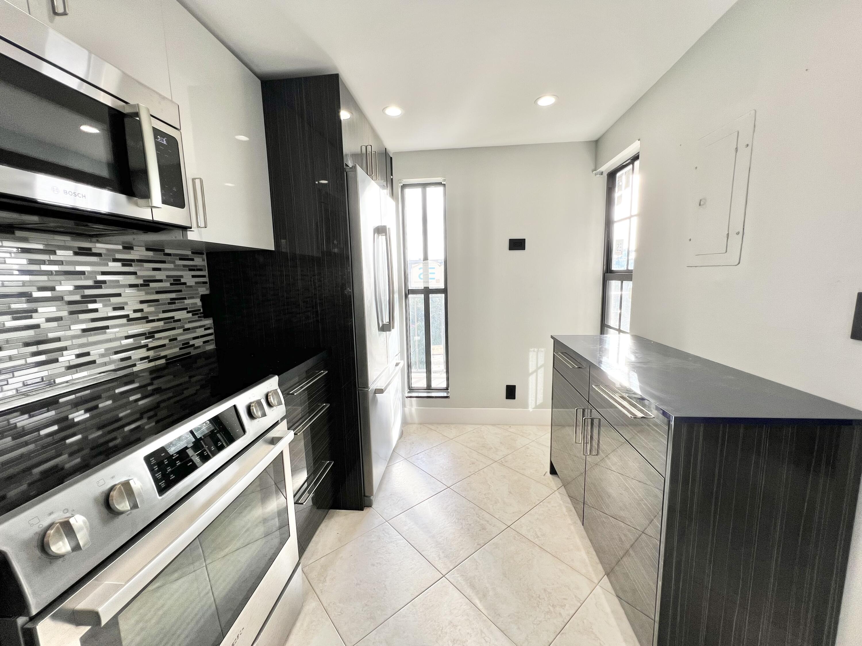 17 Royal Palm Way, Unit 503 Boca Raton, FL 33432 - Photo 4 of 29 a kitchen with stainless steel appliances granite countertop a stove and a microwave