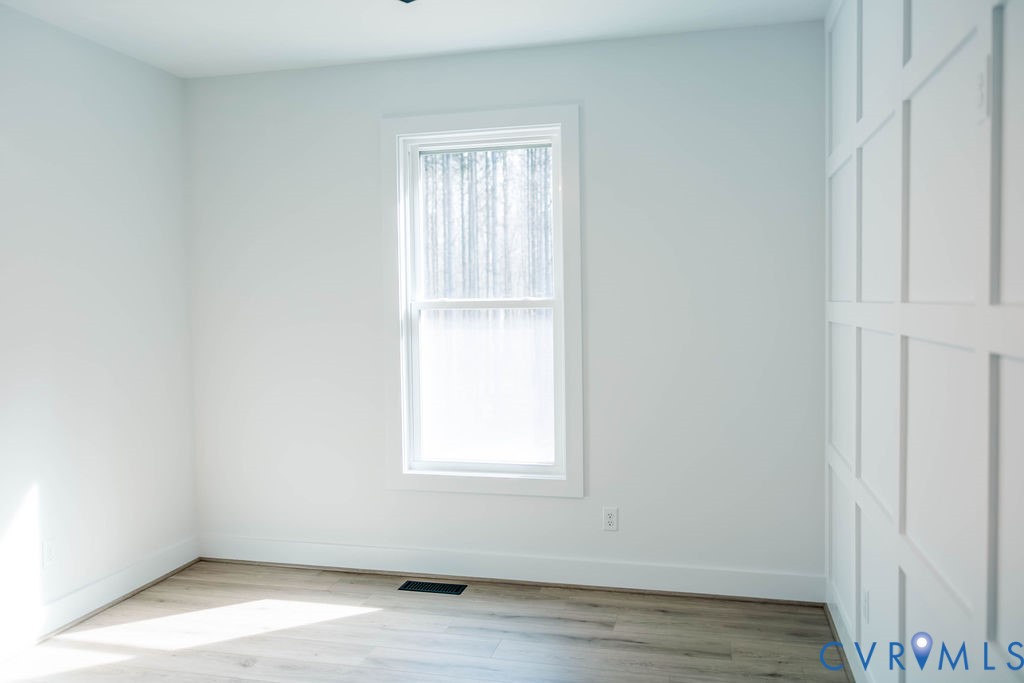 157 Barringer Lane Bumpass, VA 23024 - Photo 53 of 65 an empty room with wooden floor and windows