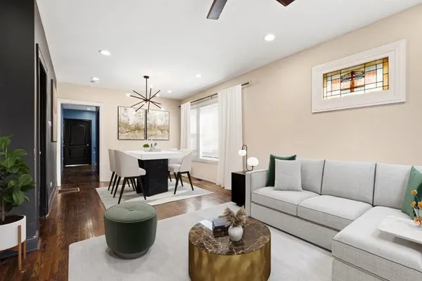 a living room with furniture kitchen view and a large window