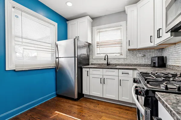a kitchen with stainless steel appliances granite countertop a refrigerator sink and stove