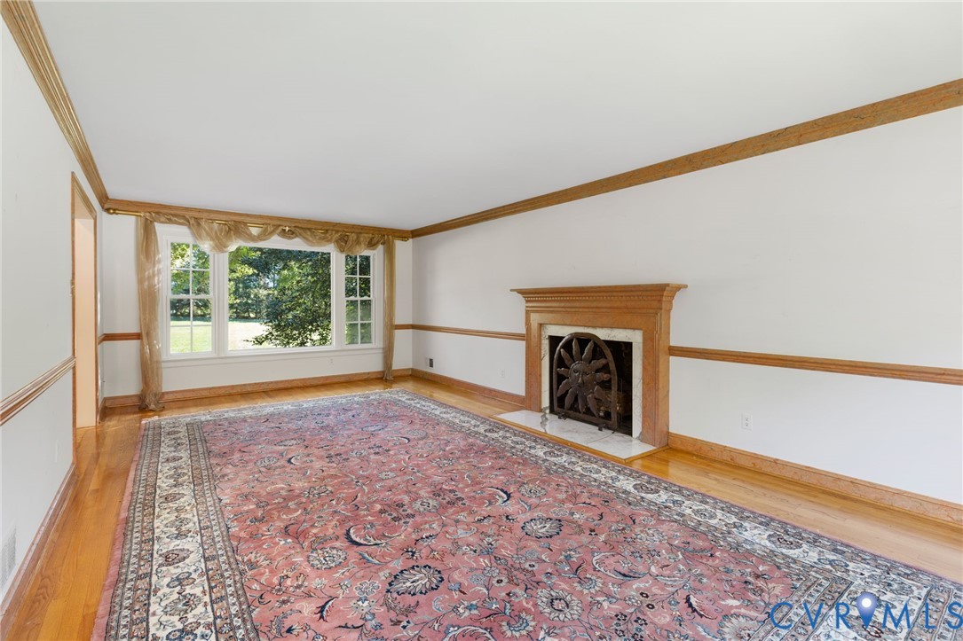 5212 Beddington Road Richmond, VA 23234 - Photo 6 of 22 a view of an empty room with a fireplace and a window