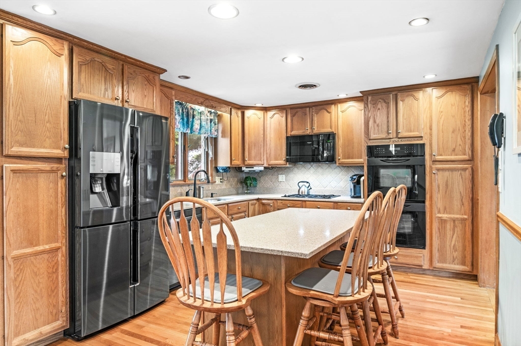 30 Lanark Road Malden, MA 02148 - Photo 14 of 40 a kitchen with stainless steel appliances granite countertop a refrigerator a stove a sink a dining table and chairs with wooden floor