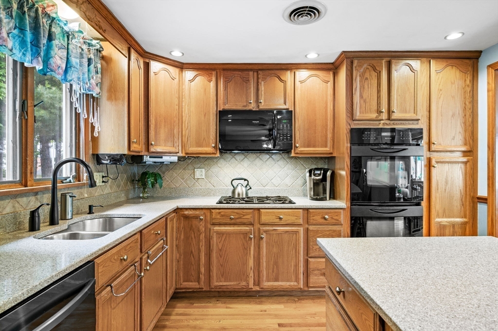 30 Lanark Road Malden, MA 02148 - Photo 16 of 40 a kitchen with stainless steel appliances granite countertop a stove a sink and a microwave