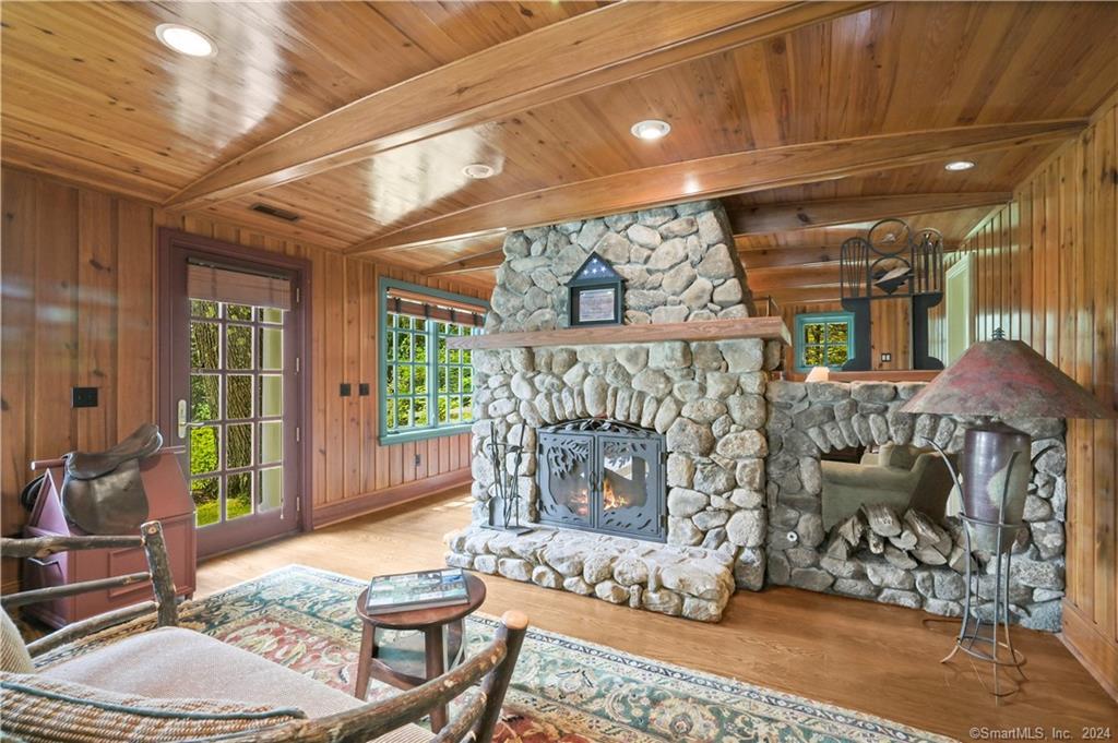 27 Old Hattertown Road Redding, CT 06896 - Photo 1 of 1 Romantically adorned with Oak Floors, Ship Ceiling, and sitting area in front of a two-sided native Stone Adirondack Fireplace - French door steps out to heated pool