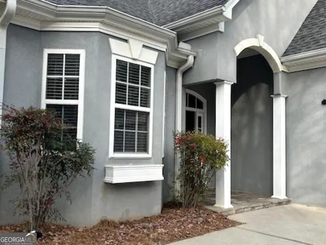 a view of a house with a potted plant and floor to ceiling window