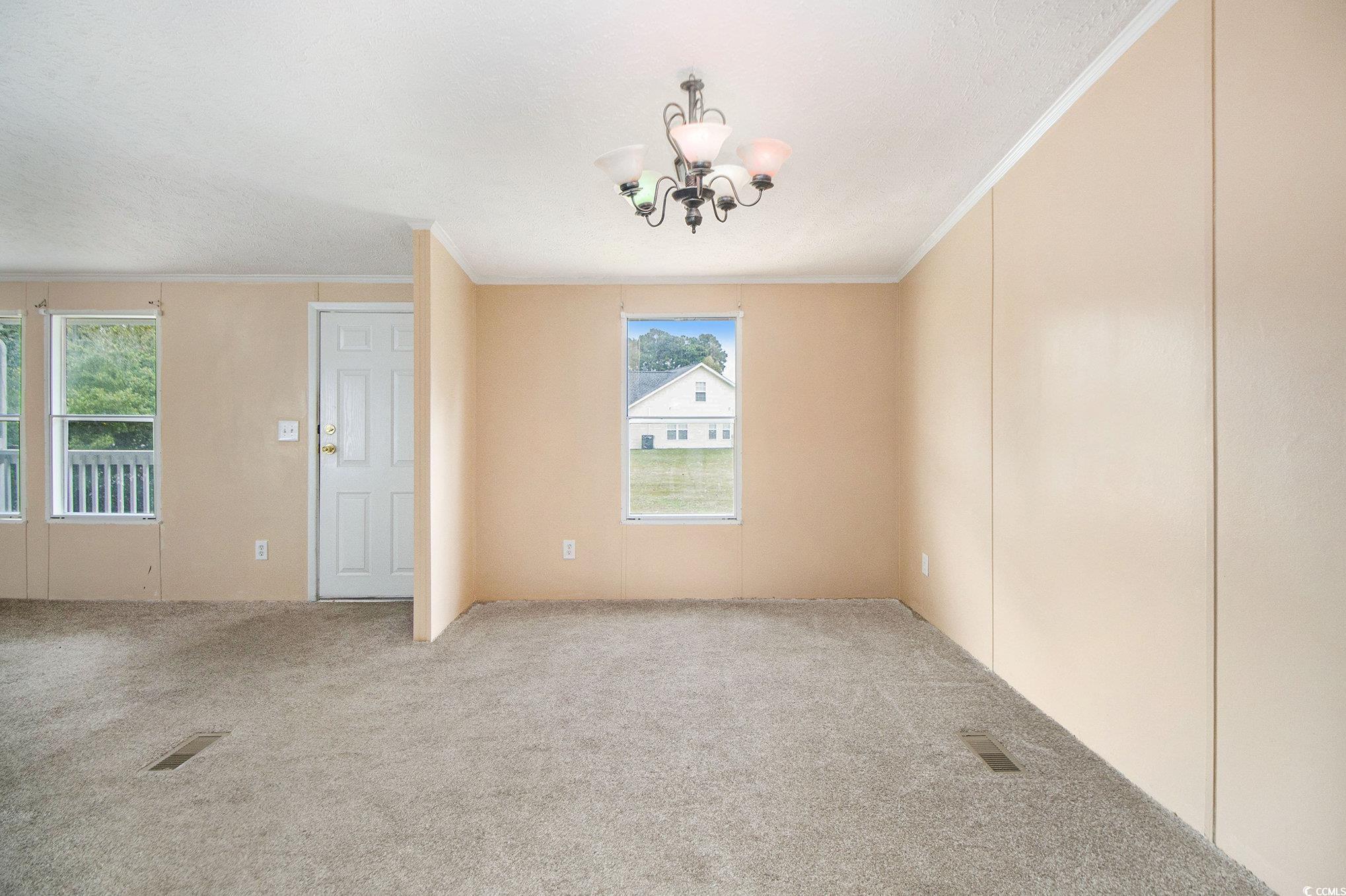 3804 Stern Drive Conway, SC 29526 - Photo 13 of 38 Unfurnished dining area with crown molding, a chandelier, and carpet flooring