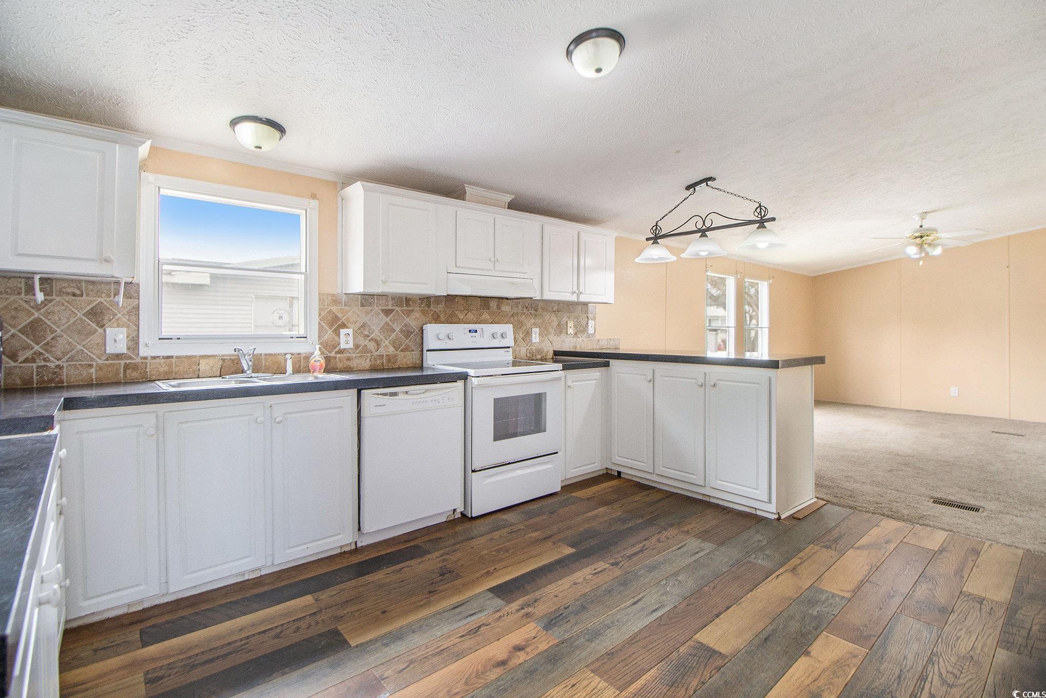 3804 Stern Drive Conway, SC 29526 - Photo 14 of 38 Kitchen with plenty of natural light, white cabinets, white appliances, backsplash, and a textured ceiling