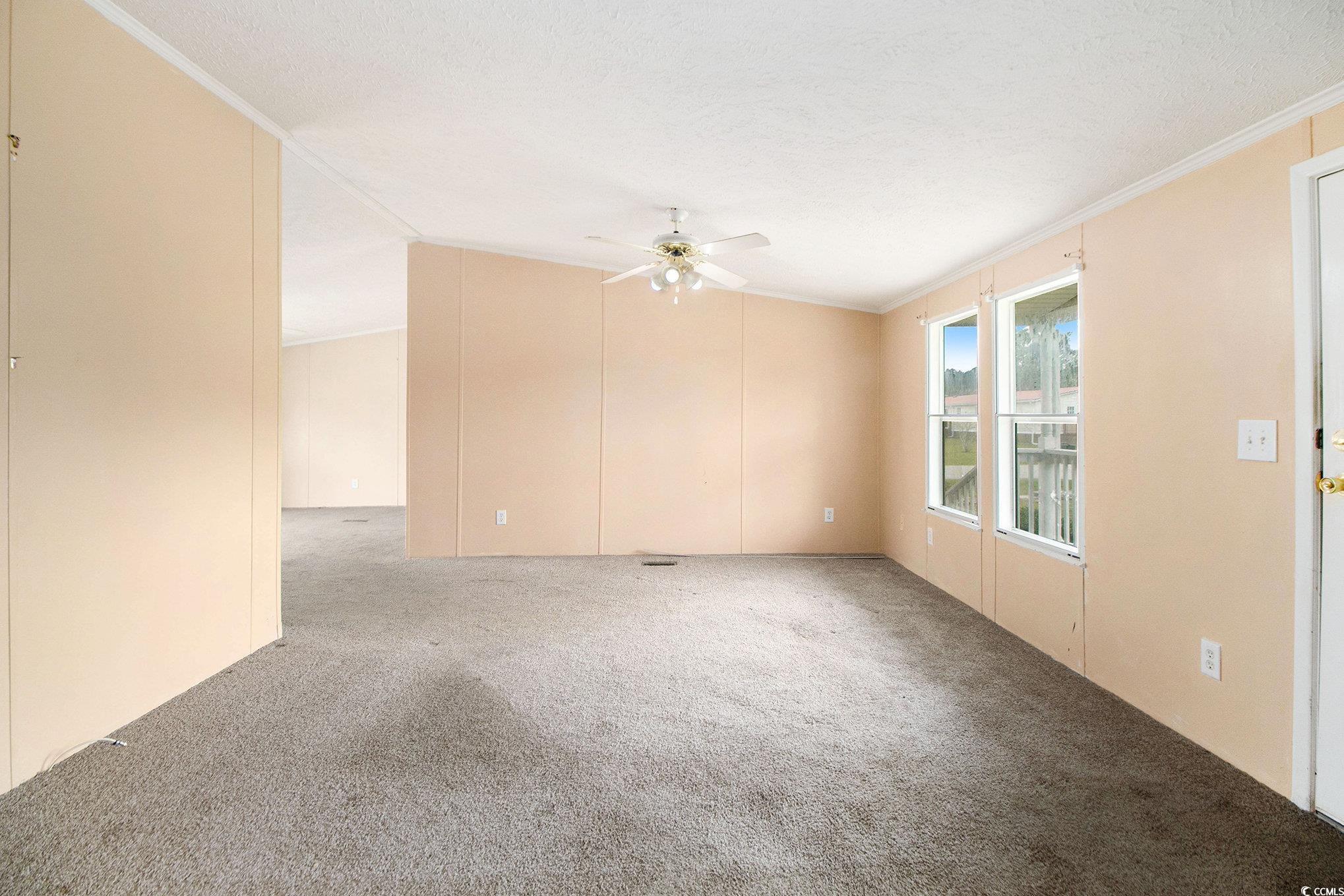 3804 Stern Drive Conway, SC 29526 - Photo 4 of 38 Unfurnished room featuring carpet floors, vaulted ceiling, crown molding, ceiling fan, and a textured ceiling