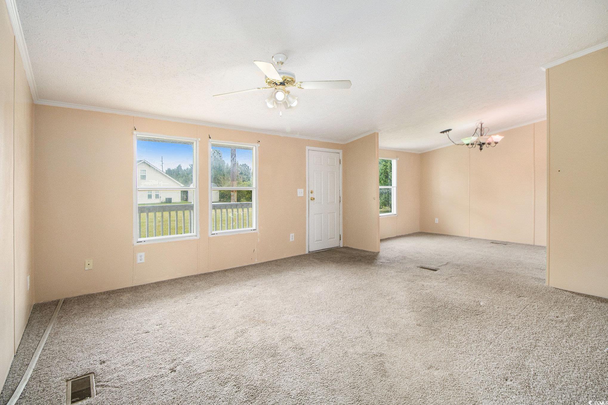 3804 Stern Drive Conway, SC 29526 - Photo 5 of 38 Unfurnished room with crown molding, carpet, a chandelier, ceiling fan, and a textured ceiling