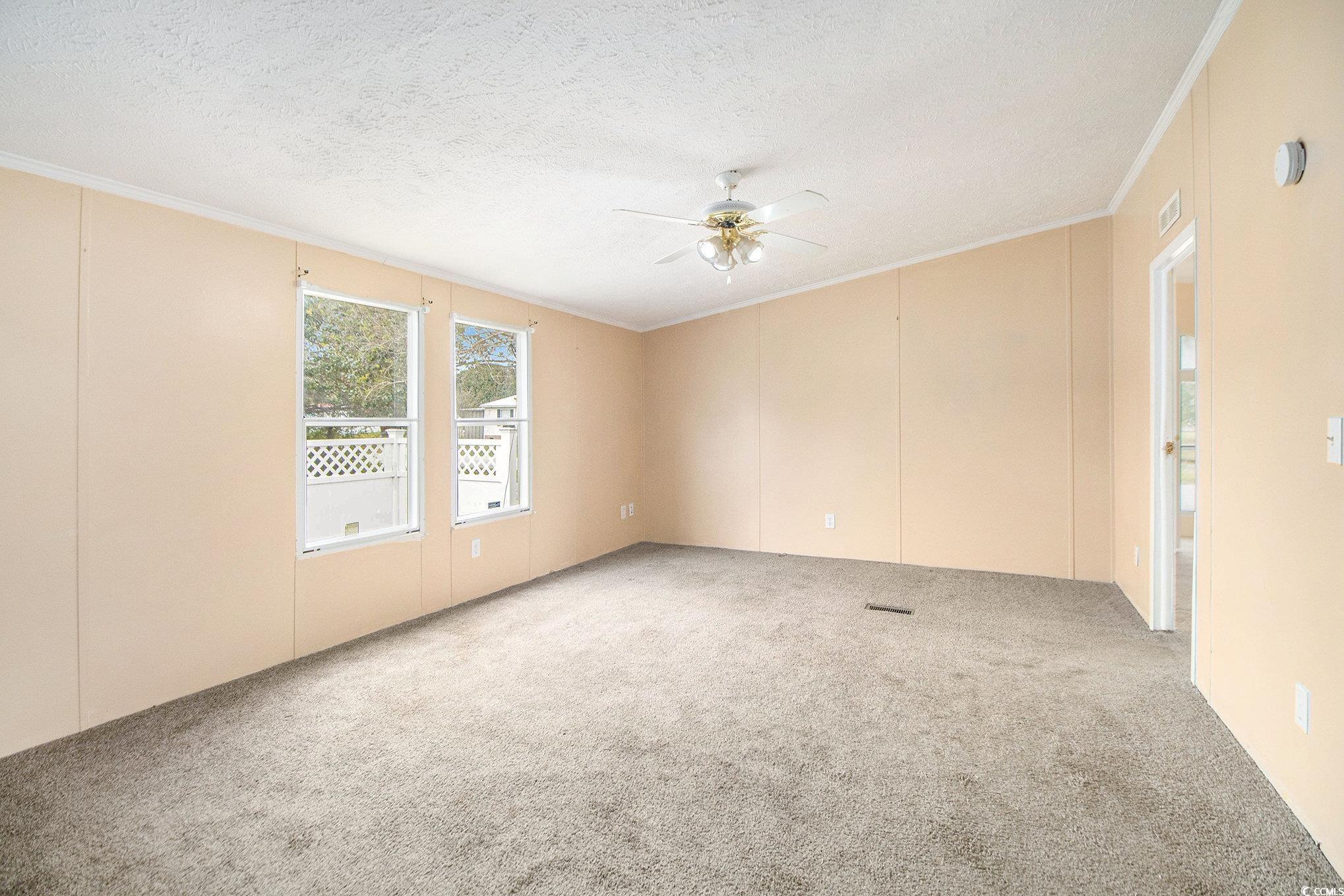 3804 Stern Drive Conway, SC 29526 - Photo 8 of 38 Carpeted spare room with ornamental molding, a textured ceiling, and ceiling fan