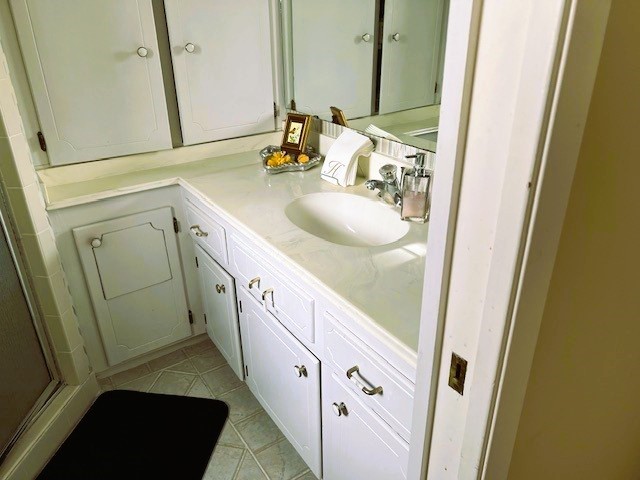 8639 Cedarbrake Drive Spring Valley Village, TX 77055 - Photo 13 of 26 Discover elegance in the primary bathroom with its sleek single sink, ample cabinetry, and charming decor, creating a perfect blend of style and functionality.