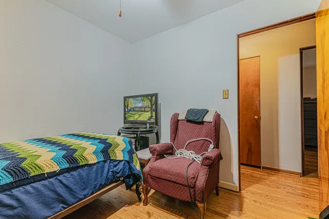 a bedroom with a bed and wooden floor