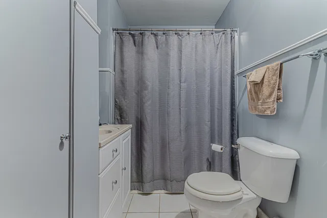 a bathroom with a toilet a sink and curtain
