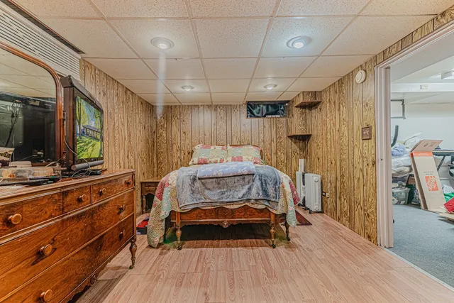a bedroom with a bed and a flat tv screen on the dresser