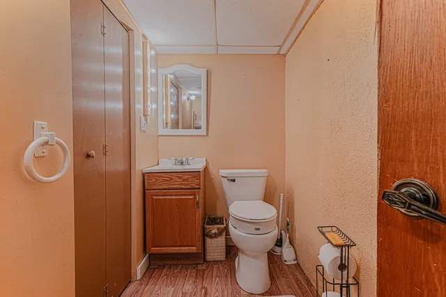 a bathroom with a granite countertop toilet and a sink