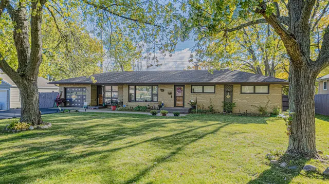 a front view of a residential houses with yard and green space