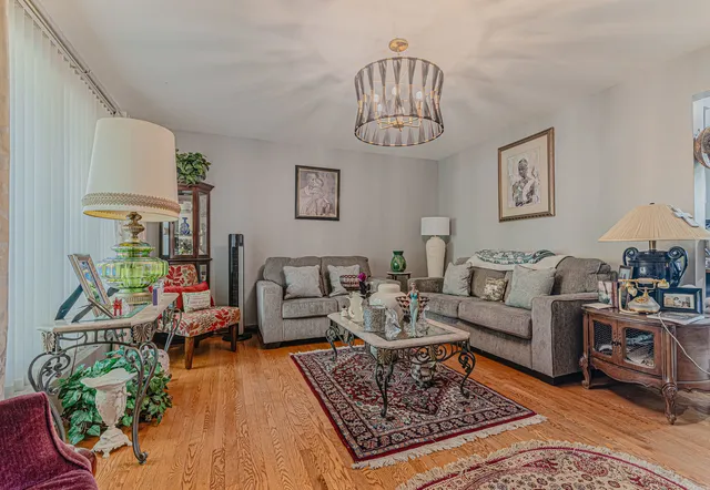 a living room with furniture a chandelier and a rug