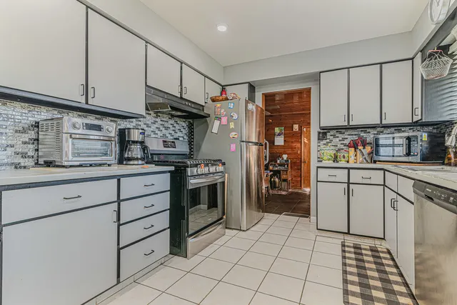 a kitchen with white cabinets and appliances
